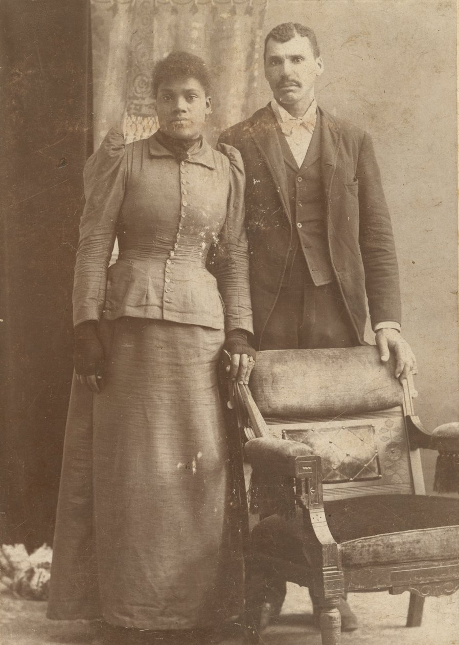 Fotografi af et afroamerikansk par, der står bag en stol, ca. 1890. af Schmitz Studio
