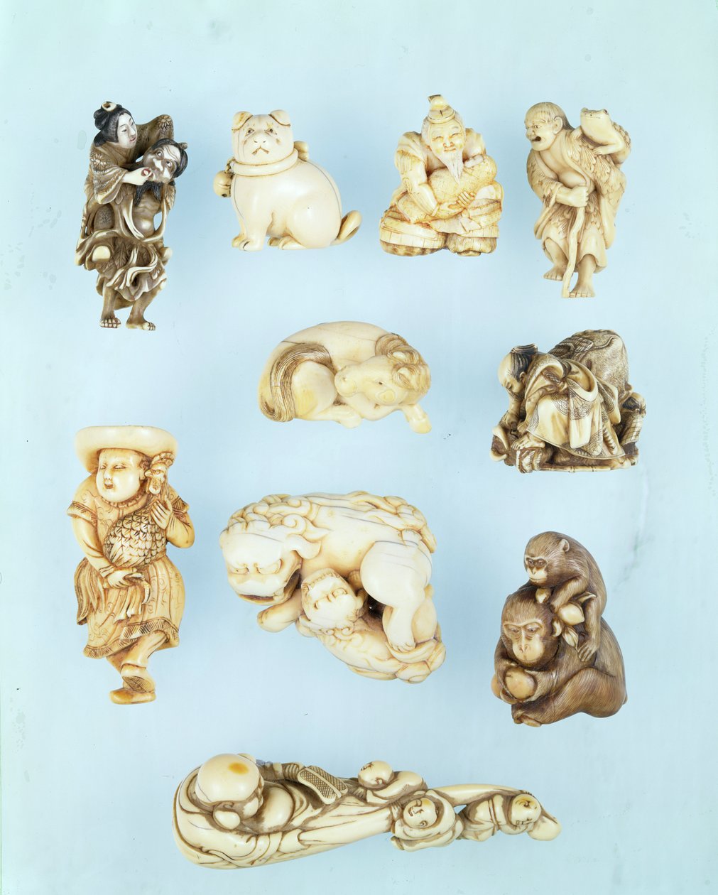 Udvalg af netsuke: Ikkuha Sennin med skøgen fra Benares; siddende hvalp; Abe no Yasuneri holder en baby; Gamma Sennin; liggende hest; kriger underkuer en løbsk okse; stående hollænder med en langhalet hane; siddende abe holder en fersken bh af Japanese School