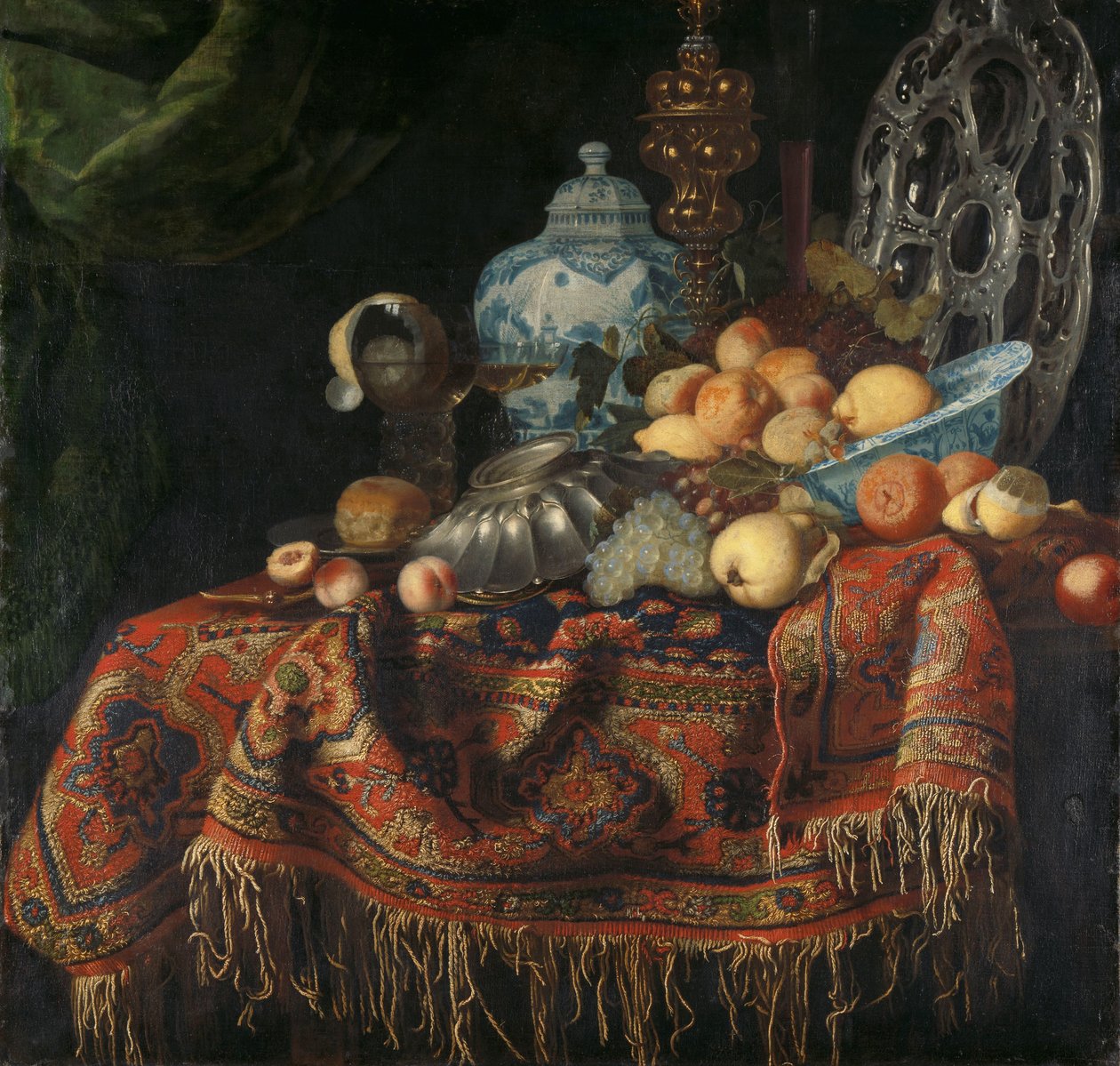 Stilleben med frugt, tallerkener og fade på et kalkuntæppe af Simon Luttichuys (attributed to)