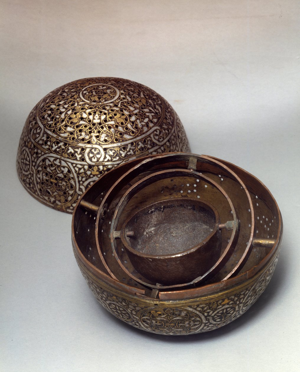 Orientalsk kunst: Burle-parfume (brænd-parfumer) eller håndvarmer (håndvarmer) fra Syrien, slutningen af det 15., begyndelsen af det 16. århundrede. Kobberlegering hamret med gravdekor, huller, indlagt med guld, sølv og sort pasta. Paris, Musée du Louvre af Syrian School