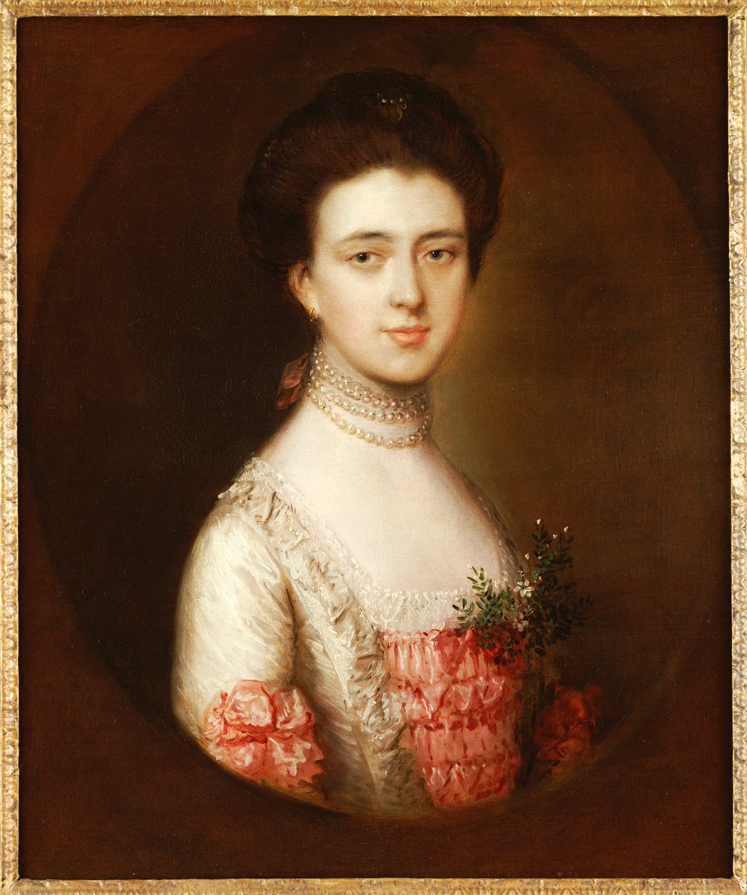 Portræt af en dame, brystlængde, i en pink og hvid kjole trimmet med blonder og en perlehalskæde af Thomas Gainsborough