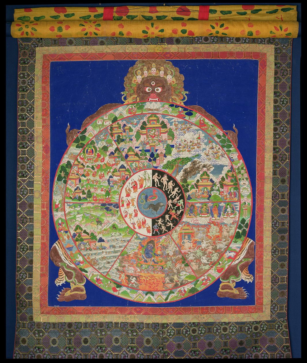 Dharmachakra Livets hjul bliver drejet af Yama, Dødens Herre, med scener, der symboliserer de tolv led, der forårsager ukontrolleret genfødsel rundt om kanten, tibetansk, 1780-1850 af Tibetan School