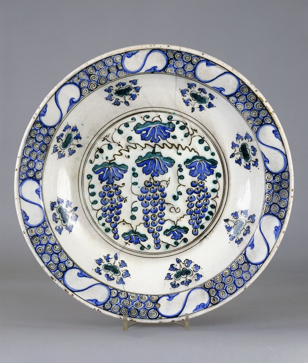 Et Iznik keramikfad, med en central rundel, der forestiller tre klaser af druer og vinblade, ca. 1570 (keramik) af Turkish School