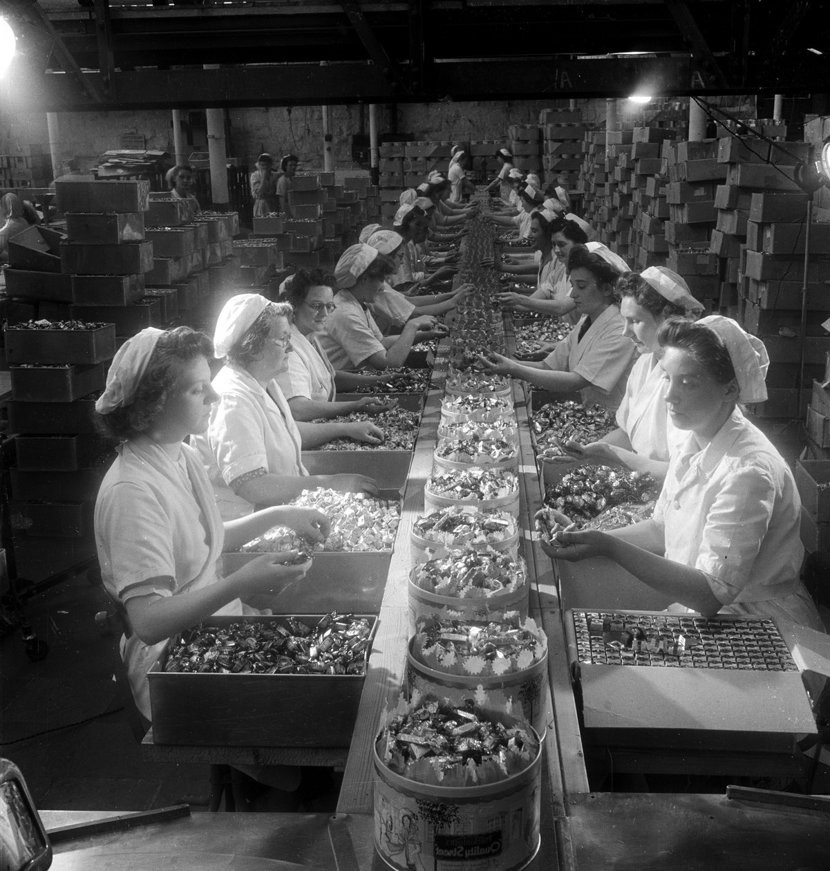 En række kvindelige arbejdere pakker "Quality Street