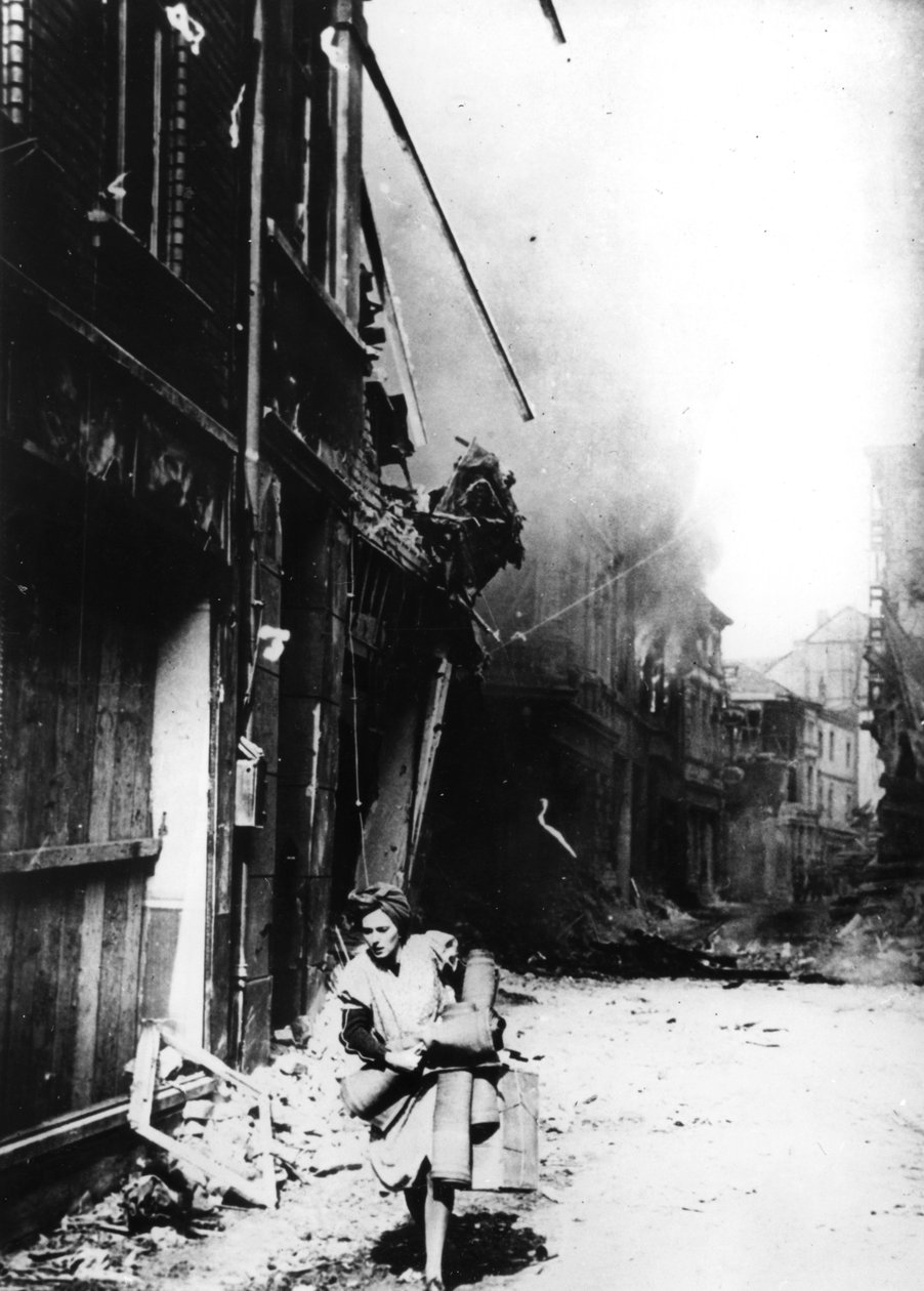 En kvinde forlader sit brændende hus i en bombet gade, Tyskland, 1945 af Unbekannt
