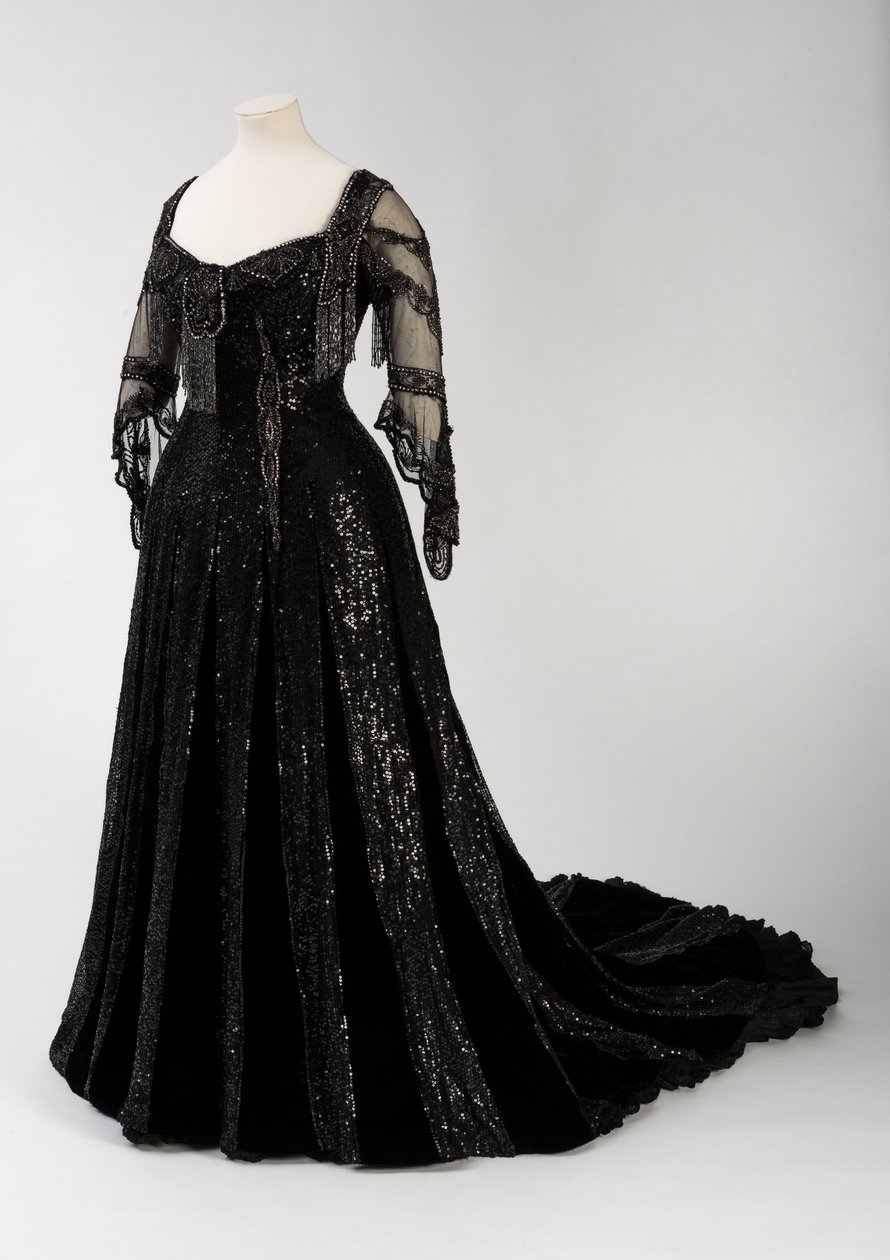 Sort aftenkjole i fuld længde båret af dronning Alexandra, med dekoration af perler og pailletter og inkorporeret dronning Alexandras signaturnavnebånd i sort silke og guld, lavet af Barolet fra Knightsbridge, London 1908-1910 (silke og fløjl) af Unbekannt