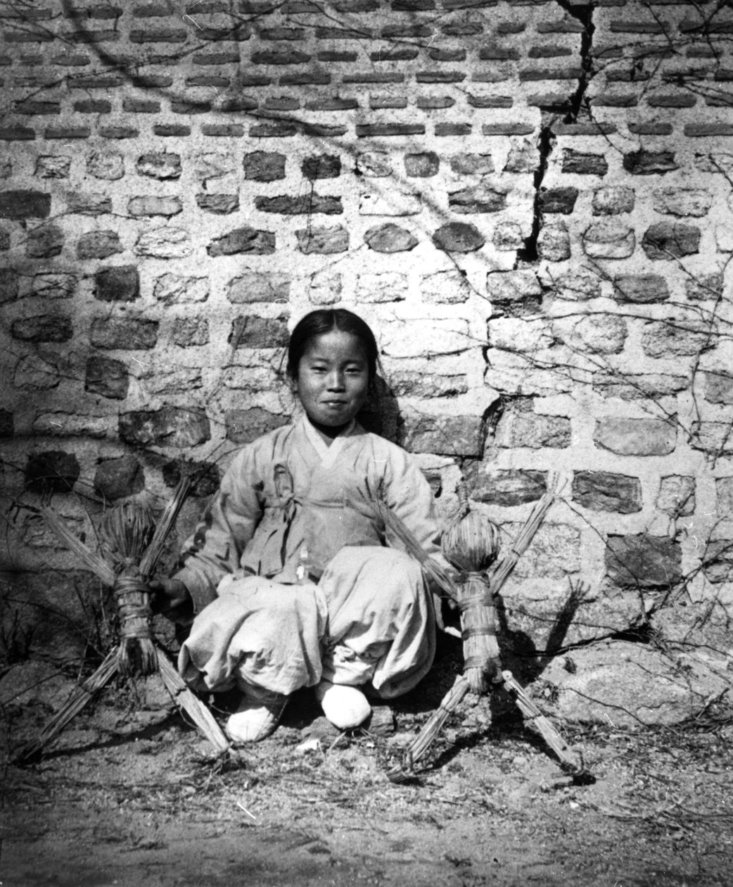 Barn sidder ved en væg, Korea, c1900 af Unbekannt