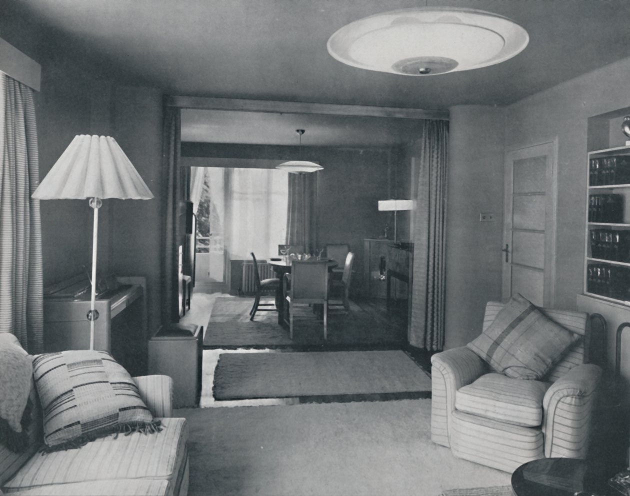 Spisestue og stue, kun opdelt af tunge gardiner i en attraktiv moderne vævning, 1942 af Unbekannt