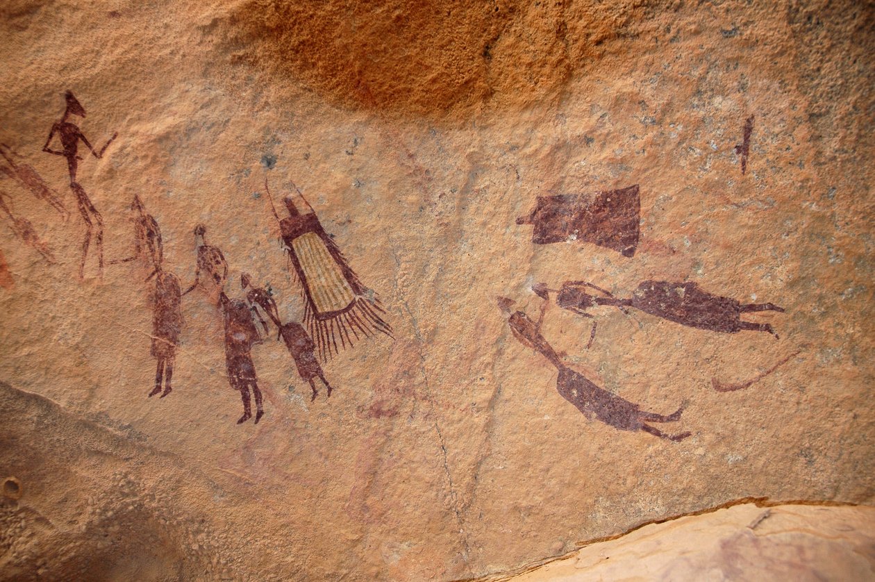 Klippekunst, forhistorie: Klippemaleri af en gruppe karakterer og "guerbaer" (ydre) har frynser og uden frynser i et udsmykket ly, i Uweinat-massivet, Sudan. Periode fra 8000 til 3000 år f.Kr. Fotografering af Unbekannt