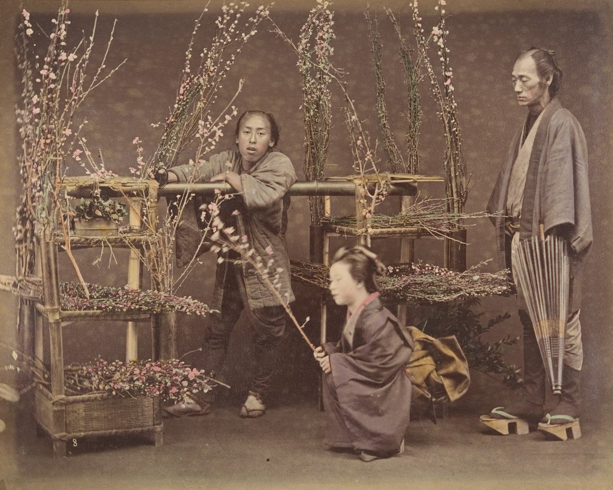 [To japanske mænd og en japansk kvinde poserer med blomstrende grene], 1870