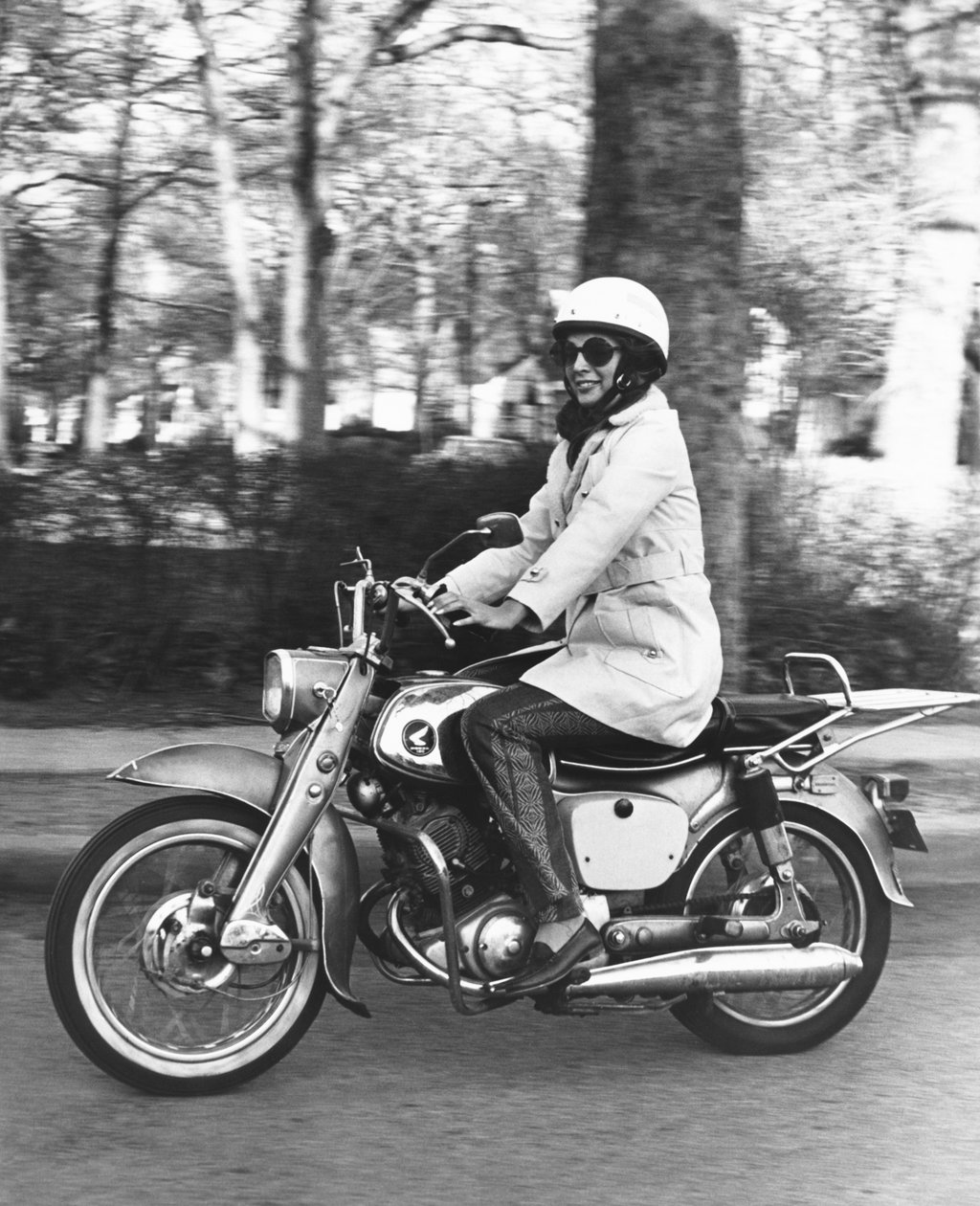 USA: ca. 1961 En kvinde kører på sin Honda 160 motorcykel. (s/h foto) af Unbekannt