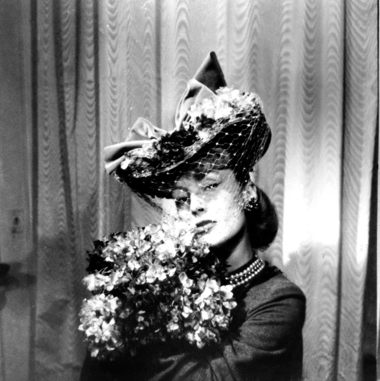 Kvinde iført hat med slør, holder en buket blomster, Paris, 1943 af Unbekannt