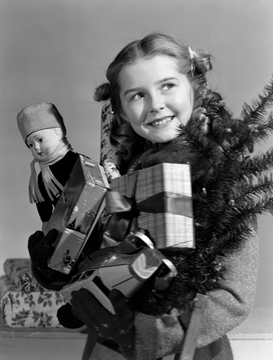 Ung pige med en favnfuld julegaver, ca 1950 af Unbekannt