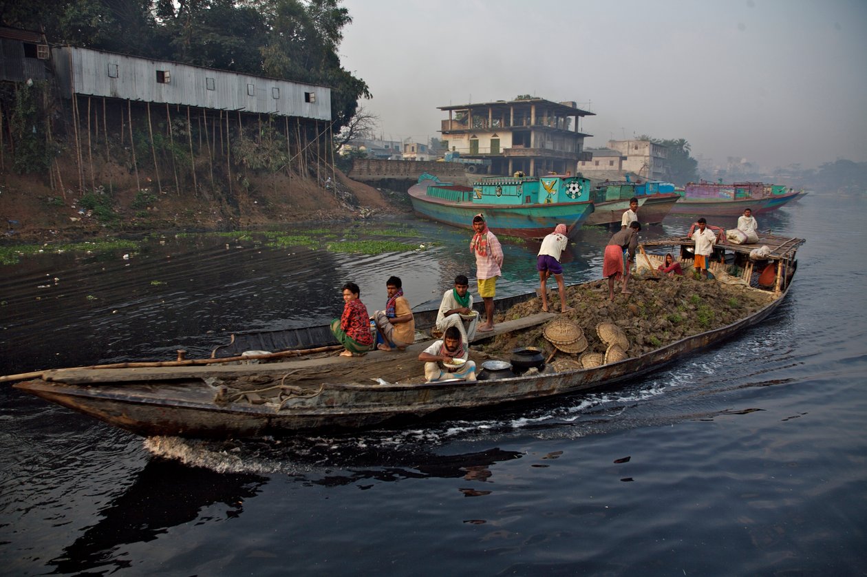 En båd med jord, brugt til at fylde lavt land op, gennem Shitalakhya-floden, nær Tongi-broen i udkanten af Dhaka by. Bangladesh. 19. februar 2007. af Unbekannt Unbekannt
