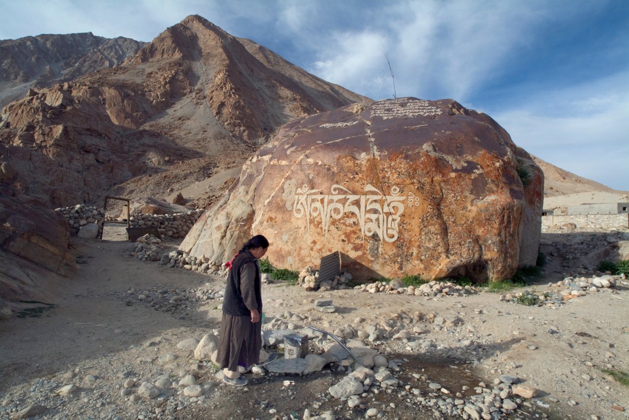 En kvinde i Ladakhi-landsbyen henter vand fra et fællesrør, Tangtse, Ladakh, Indien (foto) af Unbekannt
