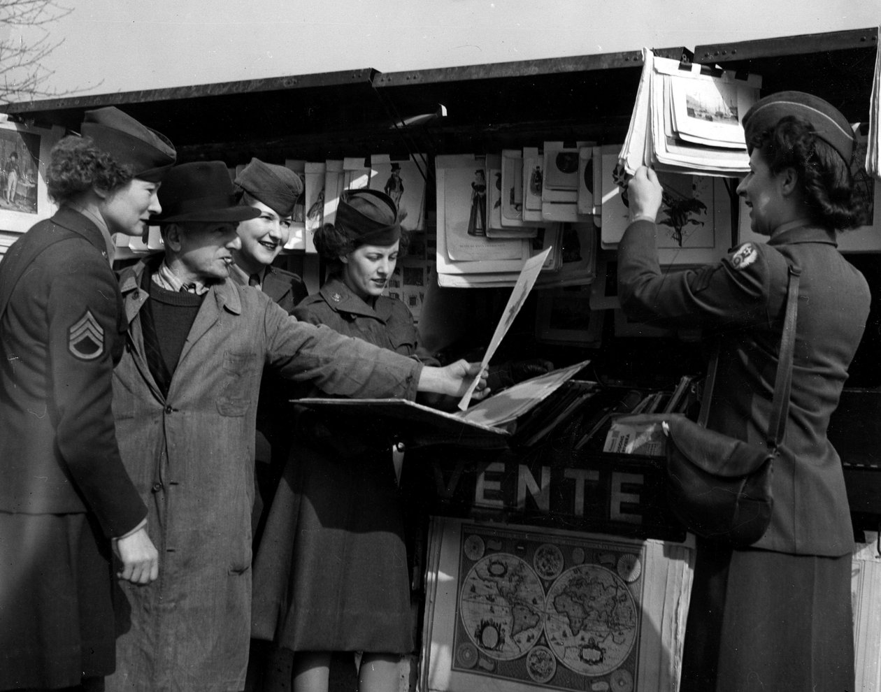 Anden Verdenskrig (1939-1945) - Anden Verdenskrig (2. Verdenskrig eller Anden Verdenskrig): Paris (Frankrig) marts 1945: Fire Wacs (Women Army Corps) fra den amerikanske hær diskuterer med en bogspiller på bredden af Seinen. af Unbekannt