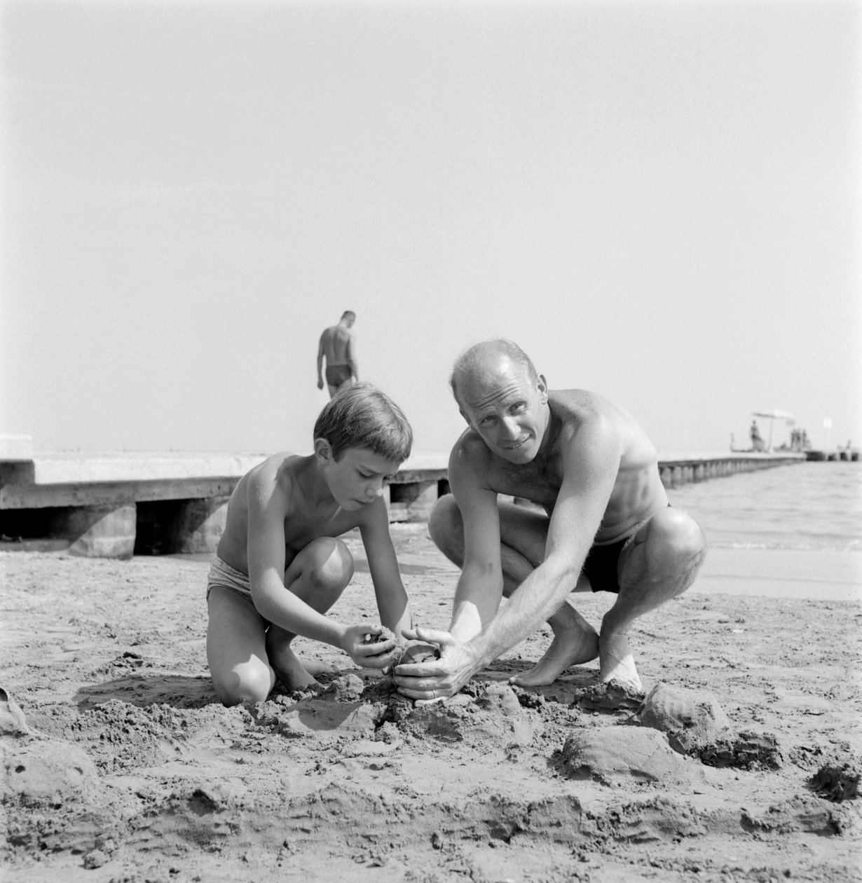 Instruktøren ALBERT LAMORISSE MED SIN SØN SKUESPILLEREN PASCAL LAMORISSE PÅ VENICE LIDO-STRAND - 1960 af Unbekannt