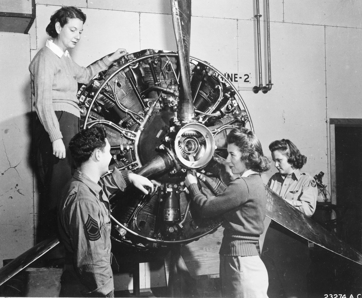 Hvepse lærer, hvor kraften kommer fra i B-17 Flying Fortress-motoren, mens de deltager i B-17-pilottræning ved Lockbourne AAB, arbejder på propelmekanismen, mens en besætningschef ser på, er de (lr): Patricia Bowser, Ann Waldner og Frances Green af Benjamin Baud