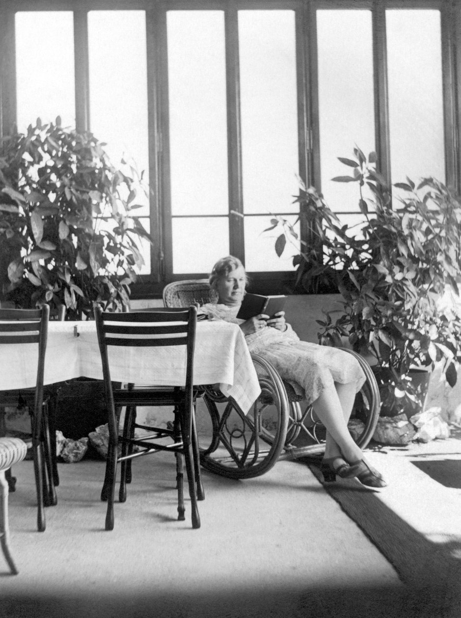 Kvinde sidder i en gyngestol og læser en bog. 1915 ca. Tyskland Historisk foto, kvinde læser, ca. 1915 af Unbekannter Künstler
