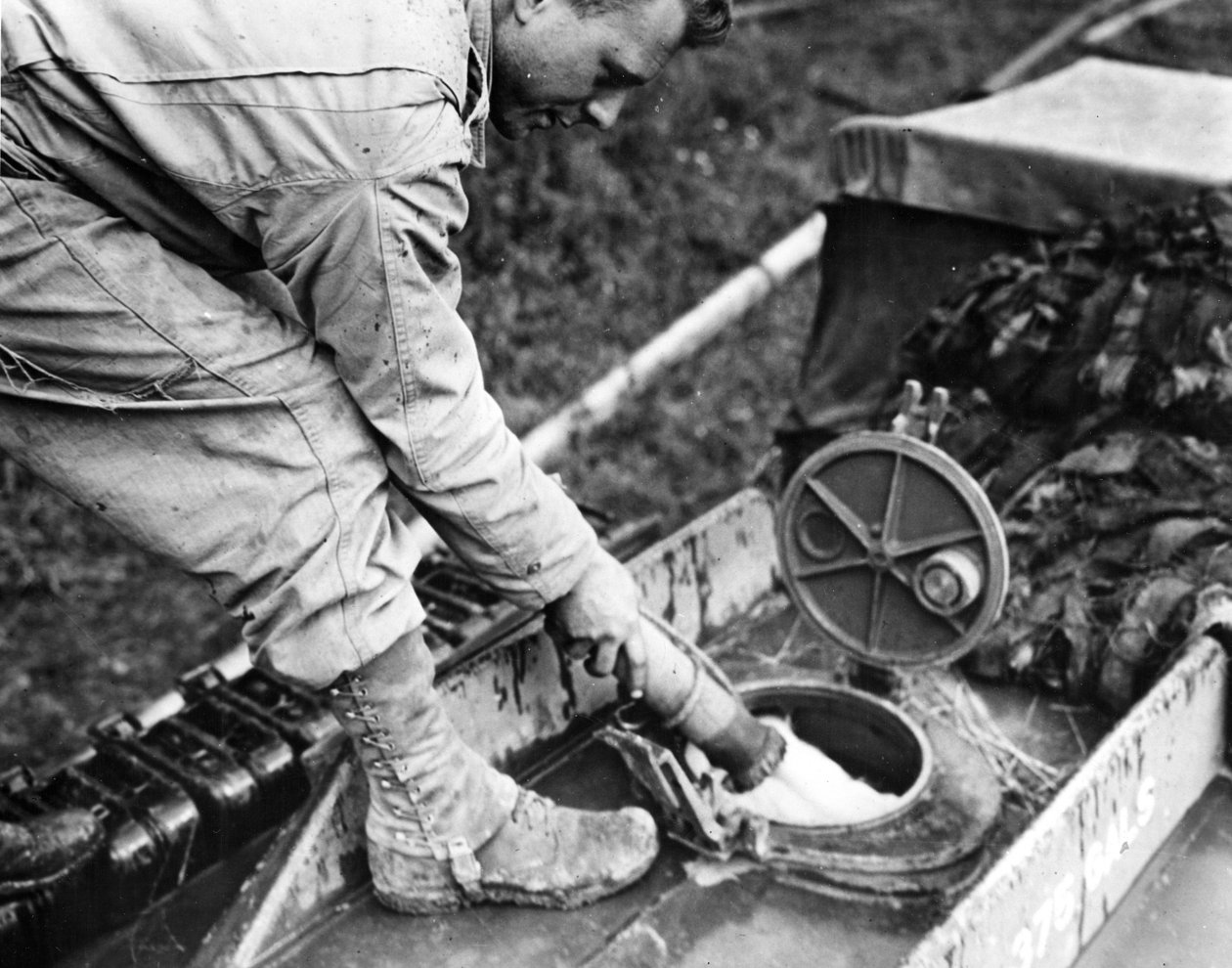 Anden Verdenskrig (WWII) (1939-1945) - Anden Verdenskrig (WWII eller 2. Verdenskrig): Normandiet (Frankrig) Sommer 1944: På en tankstation tanker en soldat fra et amerikansk transportfirma brændstof til tanken på et GMC-tankskib af Unbekannt