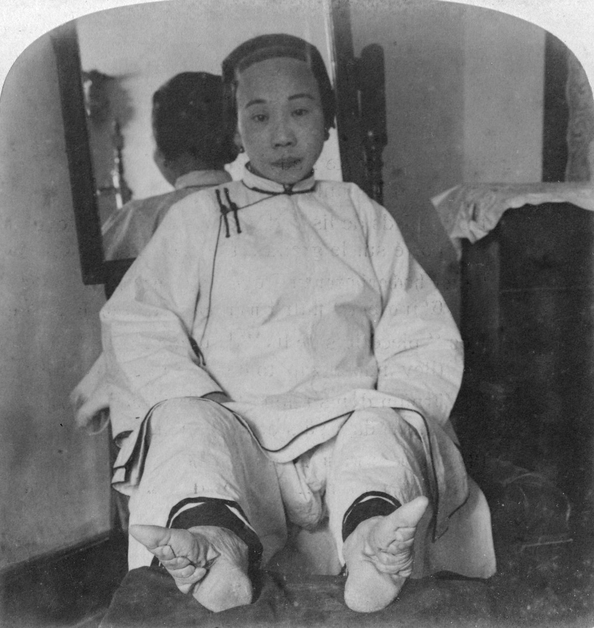 En høj kaste dame har lækre liljefødder, der viser misdannelsesmetoden, Kina, 1900. af Underwood and Underwood