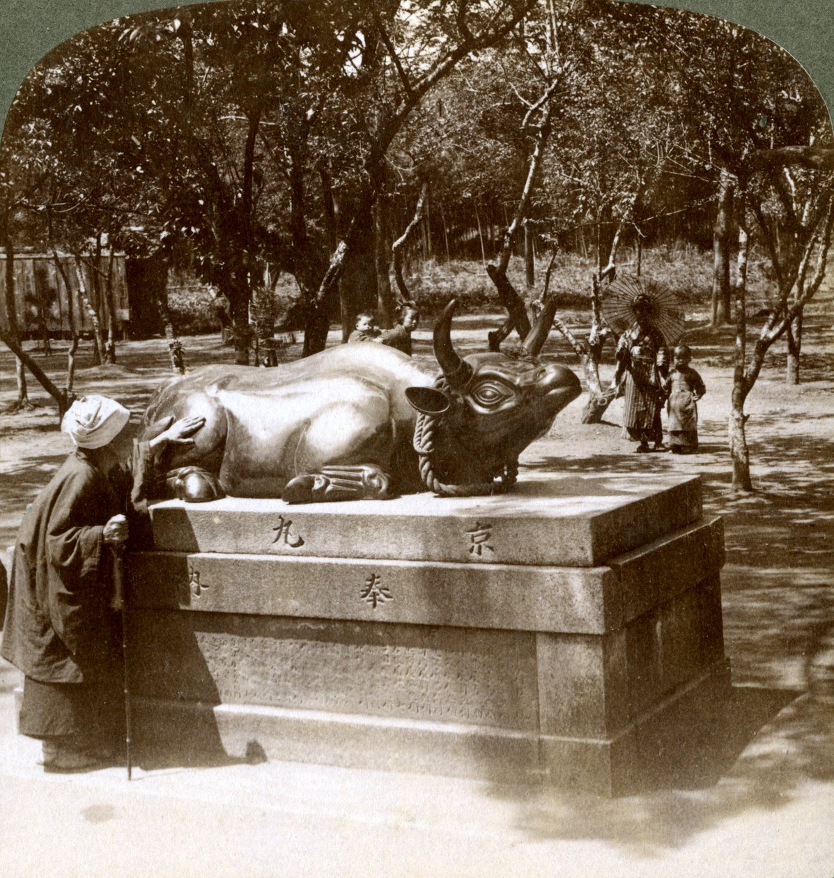 Troende kvinde, der stryger en bronzetyr for at helbrede gigt, Kitano Tenjin-templet, Kyoto, Japan, 1904 af Underwood and Underwood
