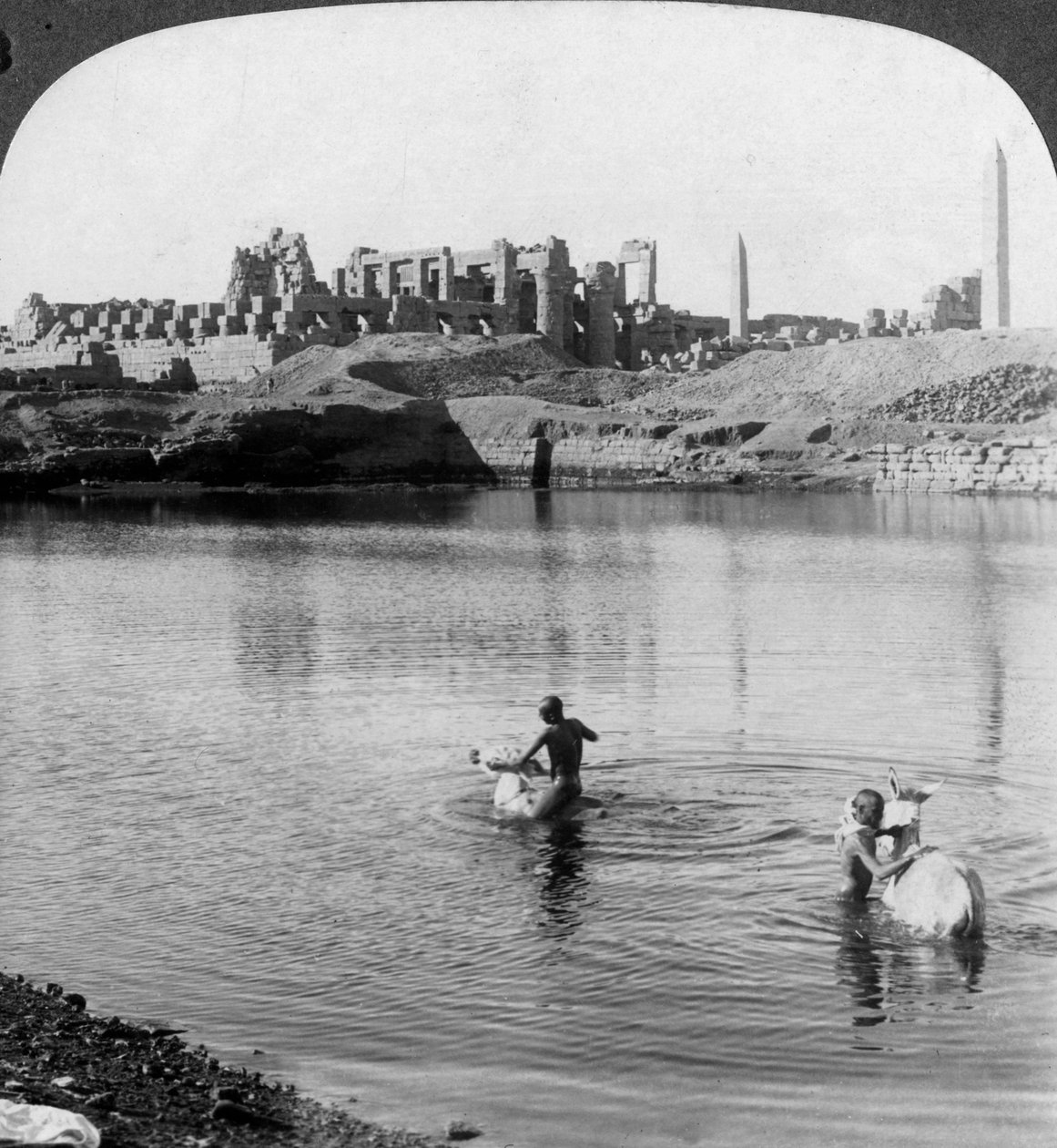 Ser over den hellige sø til det store tempel i Karnak, Theben, Egypten, 1905. af Underwood and Underwood