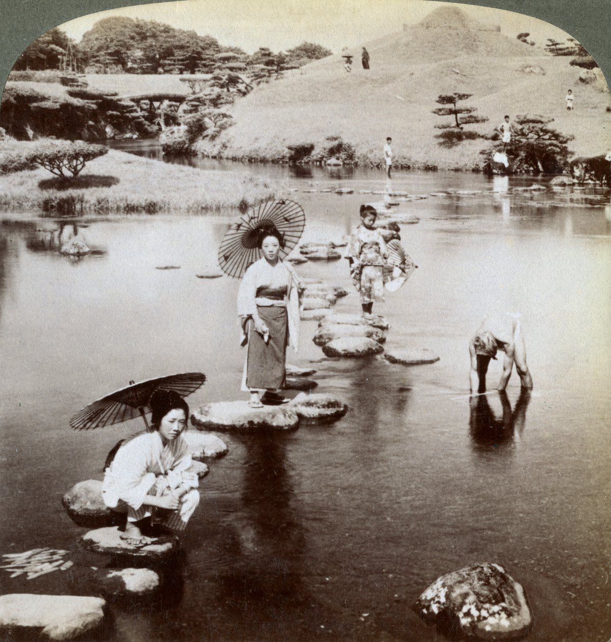 Kvinder krydser søen på trædesten, Suizen-ji Garden, Kumamoto, Japan, 1904. af Underwood and Underwood