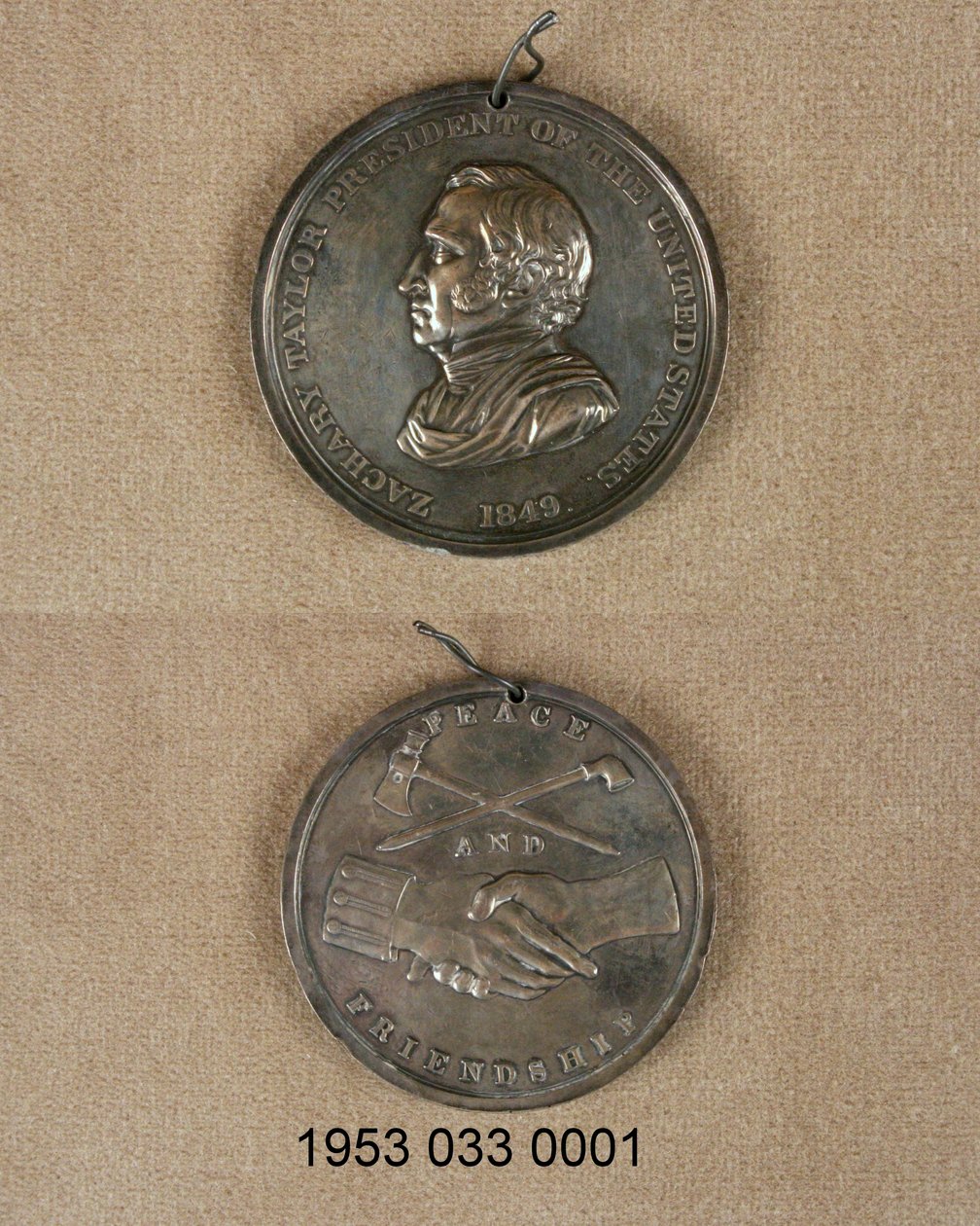 Fredsmedalje i sølv/forside med buste af Zachary Taylor/bagside med krydset pibe og økse over sammenknyttede hænder, den ene med uniform manchet af Unknown