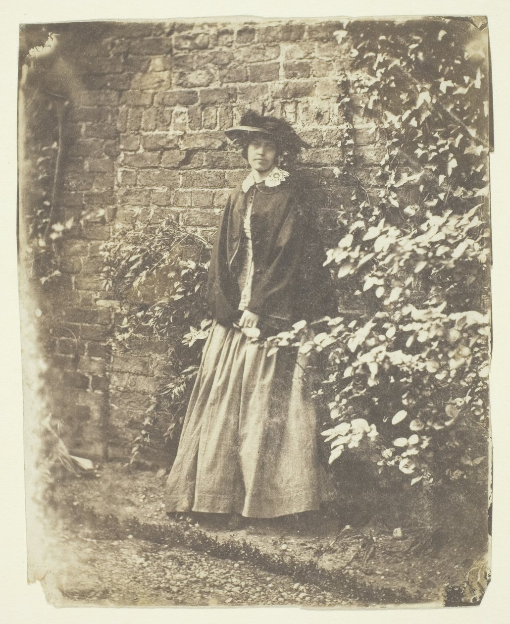 Mrs. Craik læner sig op ad mur og buske af Unknown