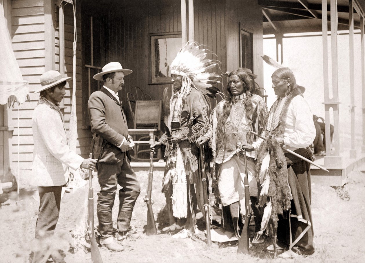 Tre cheyennere klædt i ceremonielle kostumer og iført våben hilser på en hvid ledsaget af en tolk. sd. slutningen af det 19. århundrede af Unknown artist