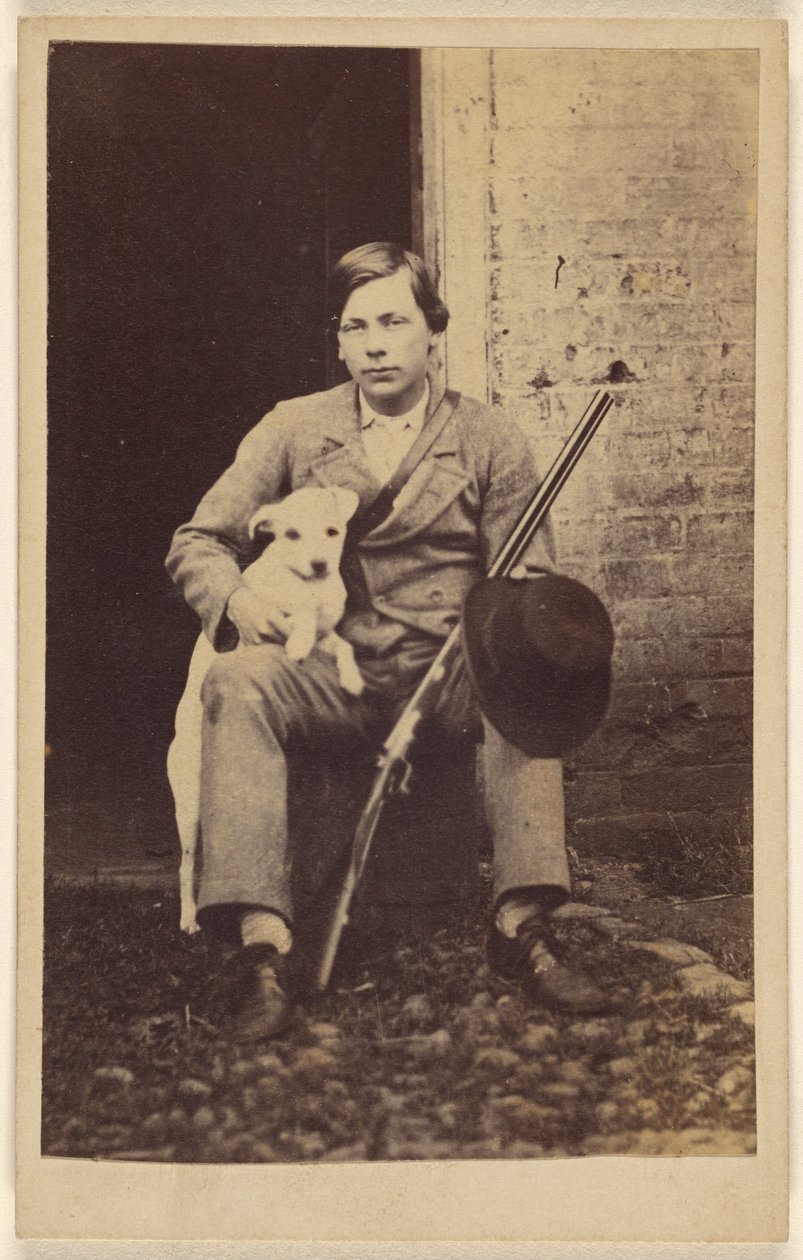 [Mand sidder med en hvid hund, en riffel og en hat, der læner sig op ad hans ben]. af Unknown artist