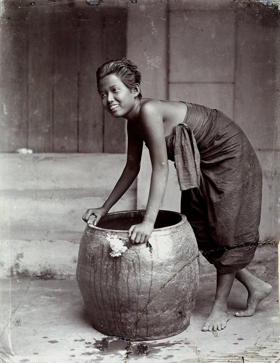 Ung smilende thailandsk kvinde skubber en stor container af Unknown photographer