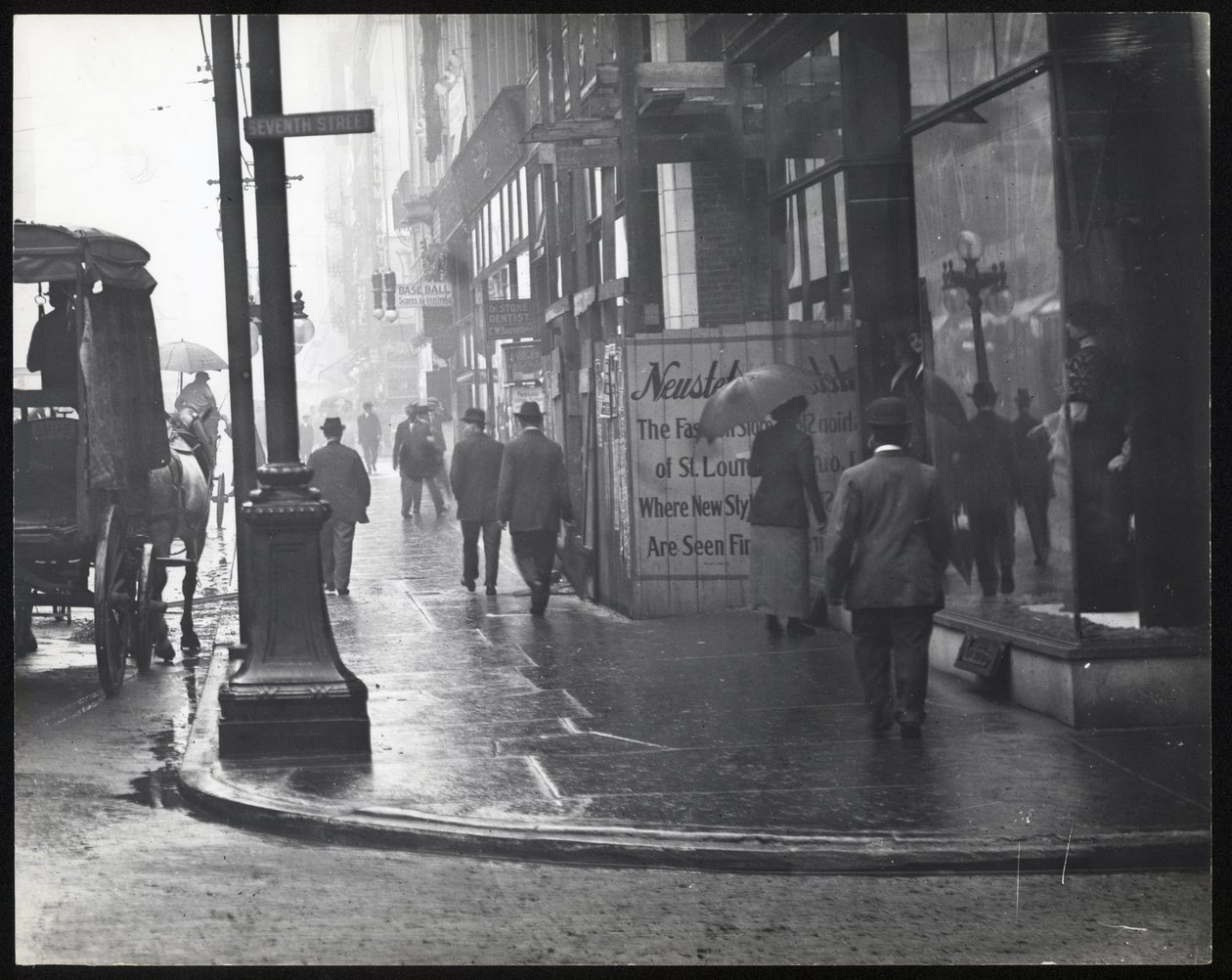 Vandret, sort / hvidt fotografi af fodgængere, der går på Washington Avenue i regnen af William G. Swekosky