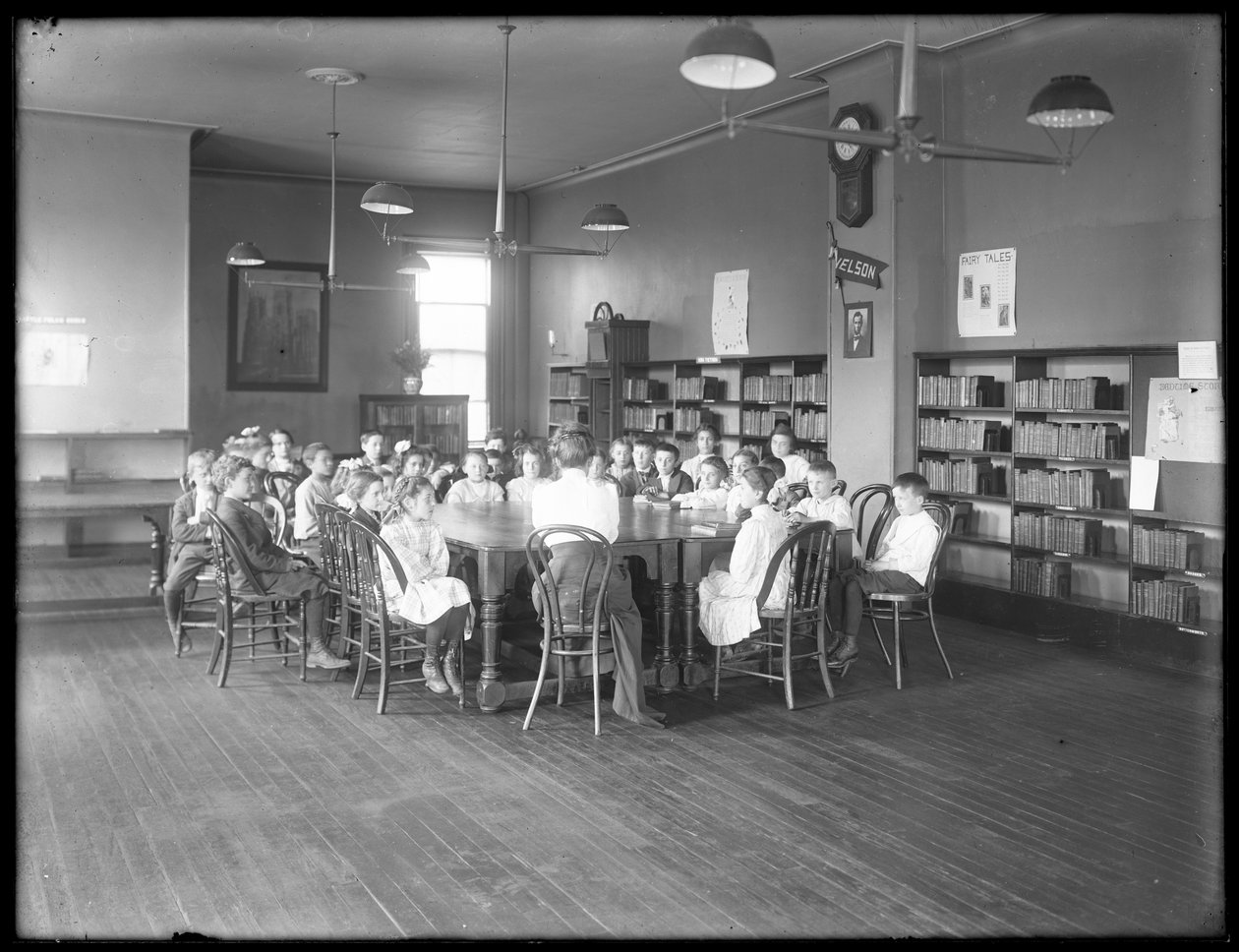 Børn lytter til en kvinde i læsesalen i en uidentificeret afdeling af Queens Borough Public Library, ca. 1910 af William Davis Hassler