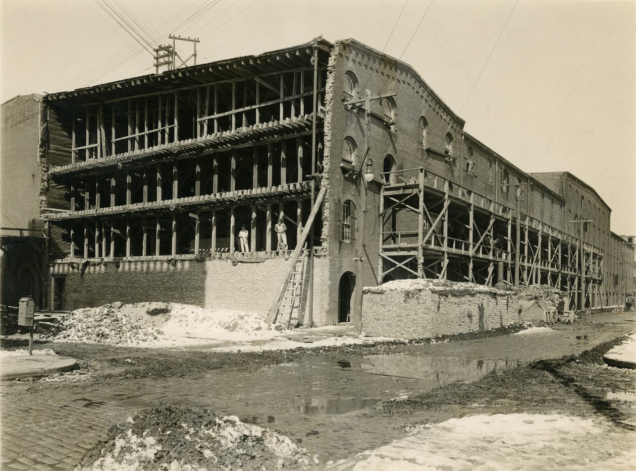 Byggeplads, to mænd stående i åben side af lagerbygning; Robbins und Ripley Engineers and Contractors, 23. marts 1916 af William Davis Hassler