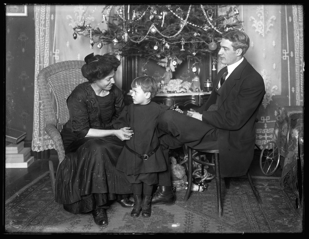 Dan Seymour og familie i uformel positur, siddende under et juletræ, julen 1912 af William Davis Hassler