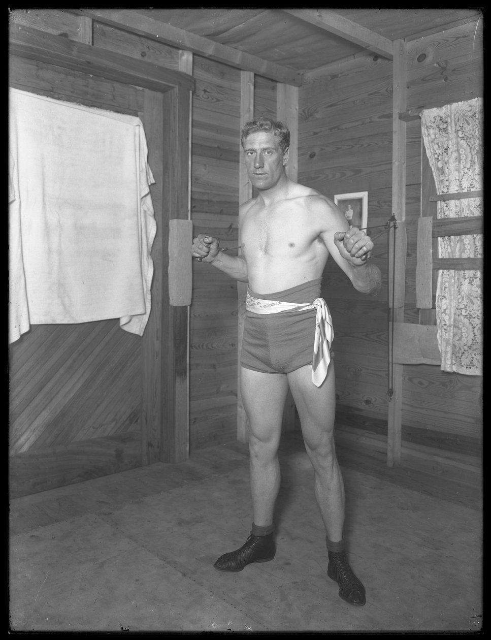 Den engelske bokser William Thomas Wells (Bombardier Billy Wells), poserer i træningsbukser med vægtskiver, ca. 1911 af William Davis Hassler