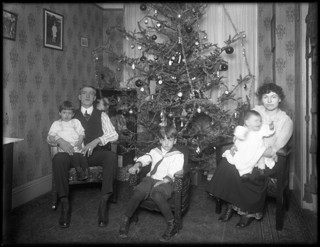 Uformelt gruppeportræt af uidentificeret familie i deres lejlighed foran et juletræ, New York City, ca. 1915-16 af William Davis Hassler