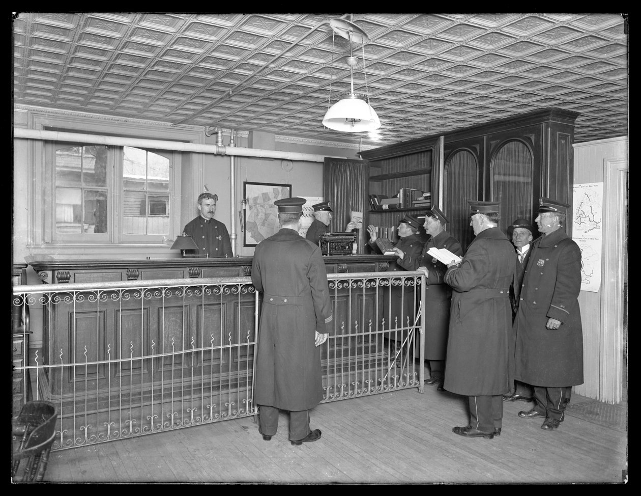 Interiør af uidentificeret politistation, viser betjente og reception, ca. 1913-14 af William Davis Hassler