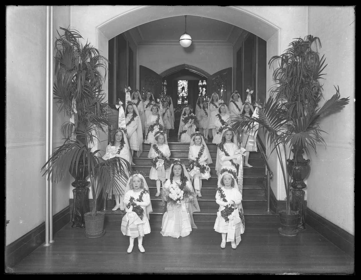 Små piger på The Roman Catholic Orphan Asylum, Kingsbridge, Bronx, vender tilbage fra kapellet i hvide kjoler med kranse og guirlander, 20. oktober 1914 af William Davis Hassler