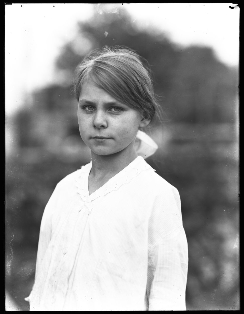 Udendørs portrætbillede af en uidentificeret lille pige i en hvid kjole, juli 1915 af William Davis Hassler