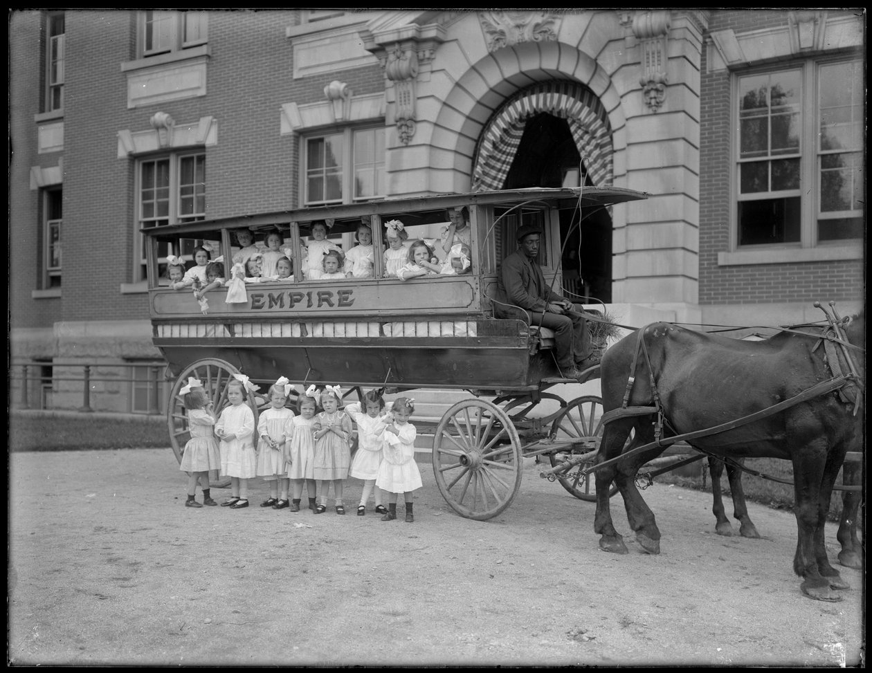 Små piger poserer i og foran en hestevogn foran en uidentificeret bygning, sandsynligvis det romersk-katolske forældreløse asyl, Kingsbridge, Bronx, ca. 1910 af William Davis Hassler