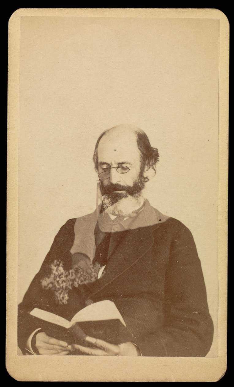 [Uidentificeret skaldet, skægget mand læser, mens han sidder]. af William H. Mumler
