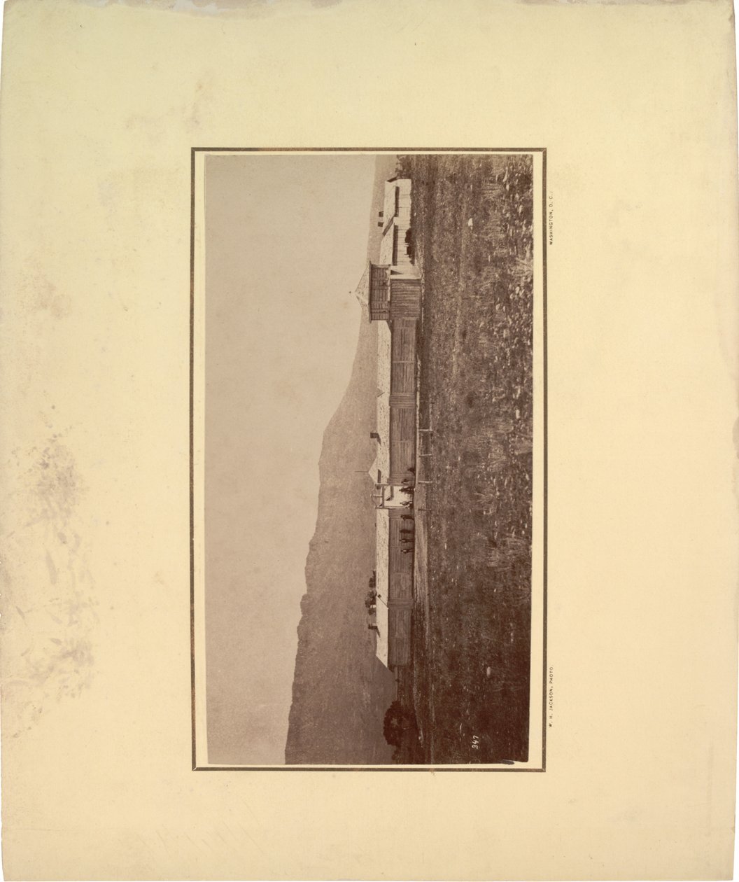 Udsigt til en palisade med flere mænd samlet ved indgangsporten, 1871 (sepia-foto) af William Hicks Jackson