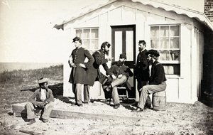 Fem borgerkrigssoldater samlet på snavset veranda uden for hjemmet, afroamerikanske unge sad i nærheden af dem, 1861-65 af American Photographer