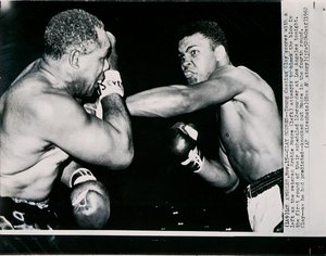 Unge Cassius Clay scorer med venstre mod veteranen Archie Moore i første runde af kampen i Los Angeles af American Photographer