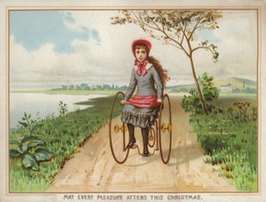 Pige kører på en trehjulet cykel på landet af American School