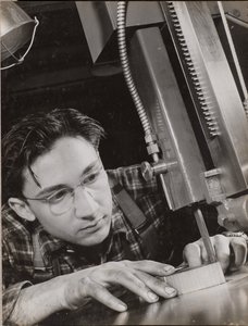 [Mand med briller arbejder intenst med en industrifil]. af Arnold Eagle