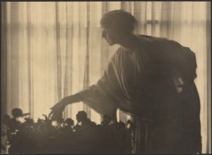 [Kvinde, der passer blomster i sin lejlighed] af Arthur F. Kales